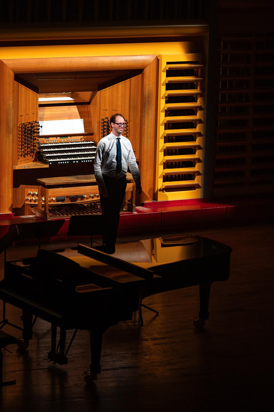 Institutsleiter und Orgelprofessor Dr. Vincent Bernhardt beim Schlussapplaus seines Antrittskonzert vor dem Orgeltisch der Riegerorgel.