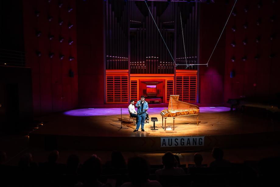 Studierende der Klasse Prof.in Dr. Stephania Neonato moderiert einem Beitrag bei einem Konzert.