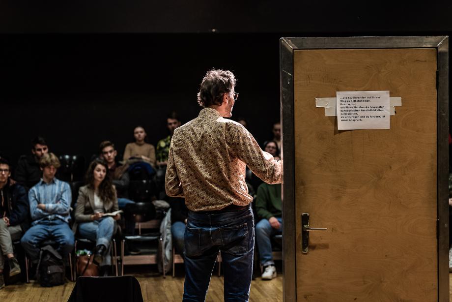 Schauspieldozent und Dramaturg Frederik Zeugke beim Vortrag am Studieninformationstag. Neben ihm befindet sich eine Probentür.