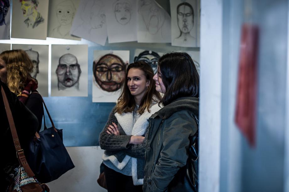 Interessierte Jugendlich vor unterschiedlichen Pupenskizzen, die im Raum an einer Leine präsentiertwerden.