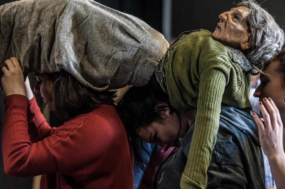 Eine große Omapuppe wird im Rahmen einer Improviationsübung über die Köpfe der Studierenden geführt.