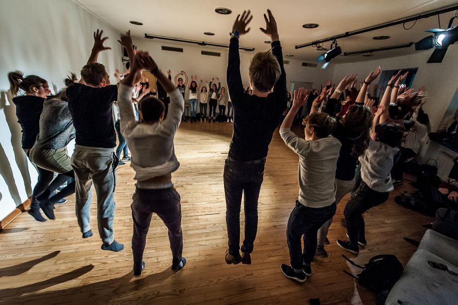 Gemeinsame Sprech- und Bewegungsübung mit interessierten Jugendlichen. Die Stimmung im Kreis wirkt ausgelassen und euphorisch.