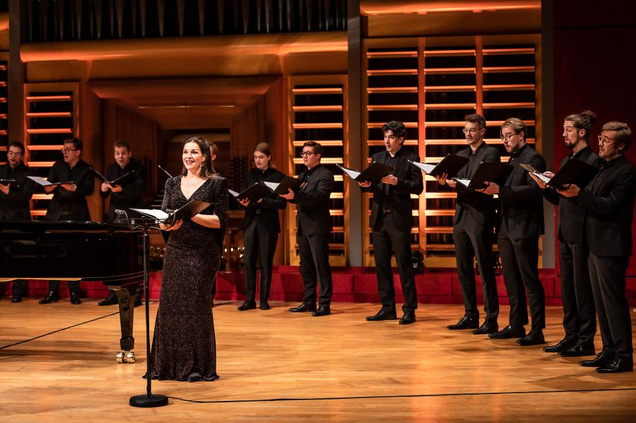 Prof.in Marion Eckstein musiziert gemeinsam mit ihrer Klasse auf dem Podium. Die Studierenden bilden einen Halbkreis um sie.