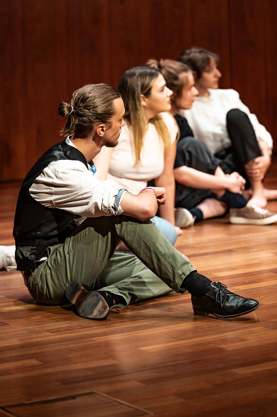 Sitzende Studierende, die ihren Blick auf eine entfernte Person gerichtet haben.