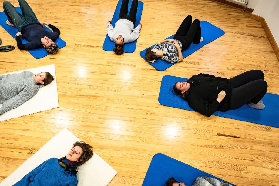 Auf Matten liegende Studierende, aus der Vogelperspektive aufgenommen.