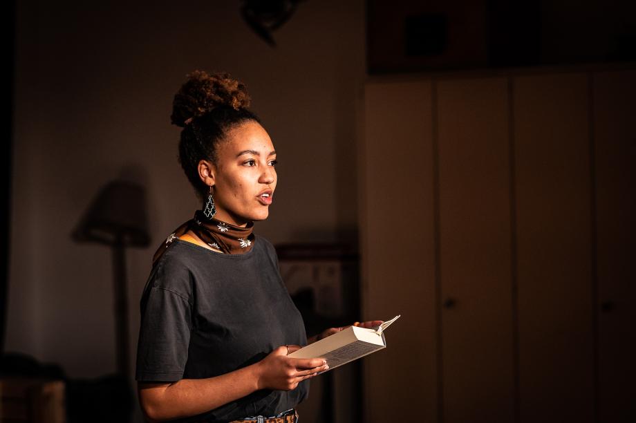 Studierende trägt eine Textpassage aus einem Buch vor.