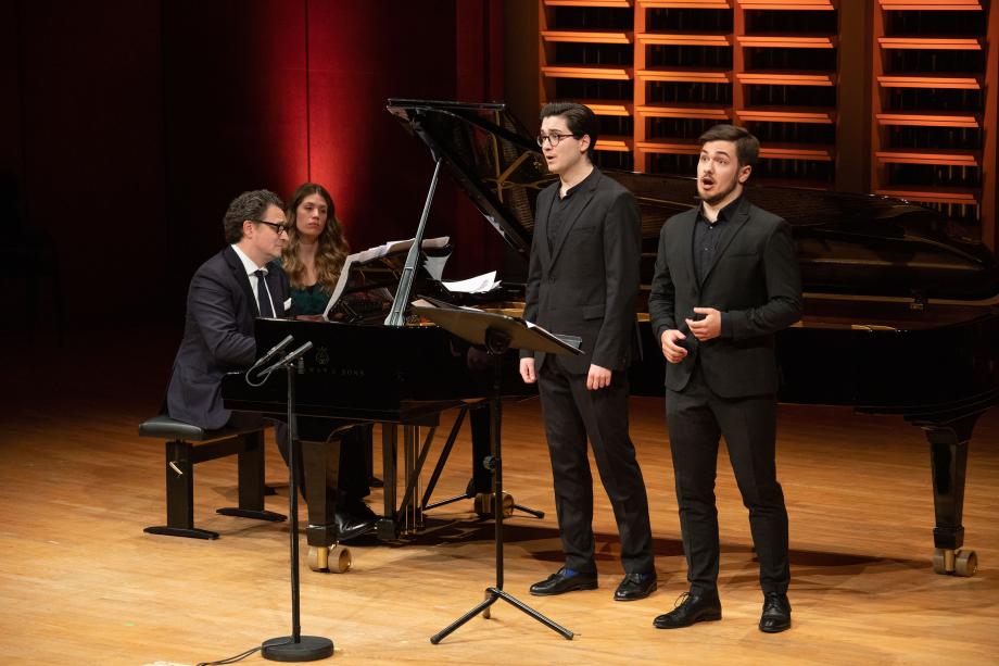 Prof. Goetz Payer am Klavier mit studentin. Studierende stehen vorne und singen.