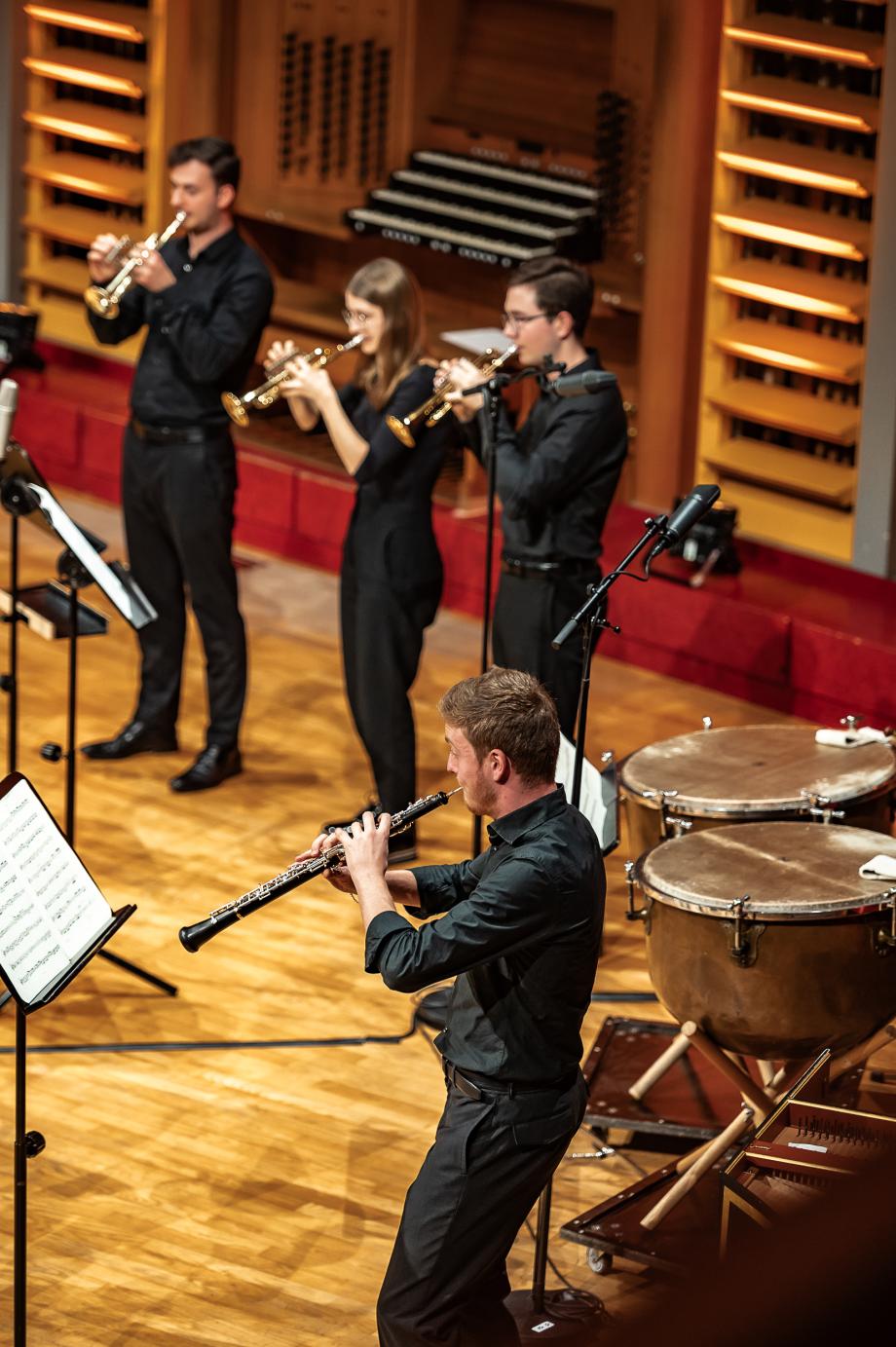 Blick vom Seitenrang des Konzertsaales auf Studierende der Bläserklassen.