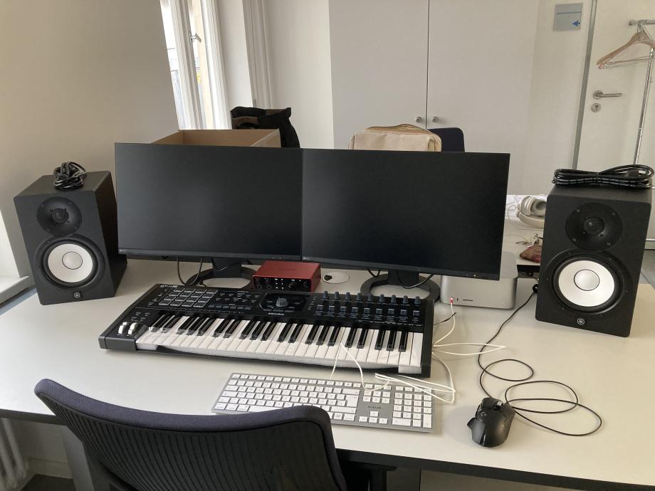 Interaktiver Arbeitsplatz mit PC, zwei Bildschirmen, Soundanlage, Midi-Keyboard und weiterem Equipment. 