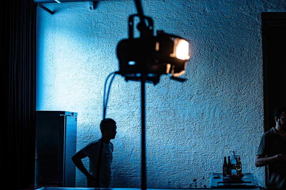 zwei Menschen im dunkeln vor einem leuchtendem Scheinwerfer.