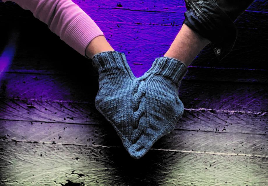 Zwei Hände halten sich und stecken in einem gemeinsamen Handschuh