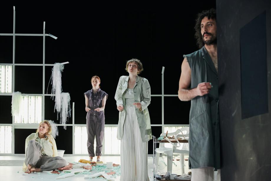 Drei Frauen udn ein Mann stehen in und vor einem mit kaputtem Styropor übersähtem Bühnenbild. 