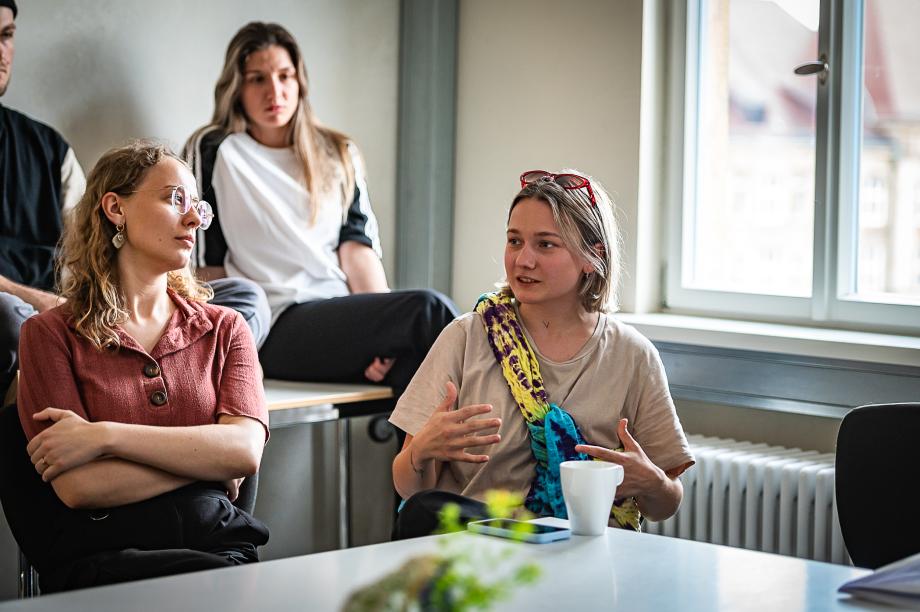 Menschen diskutierend sitzend an einem Tisch.