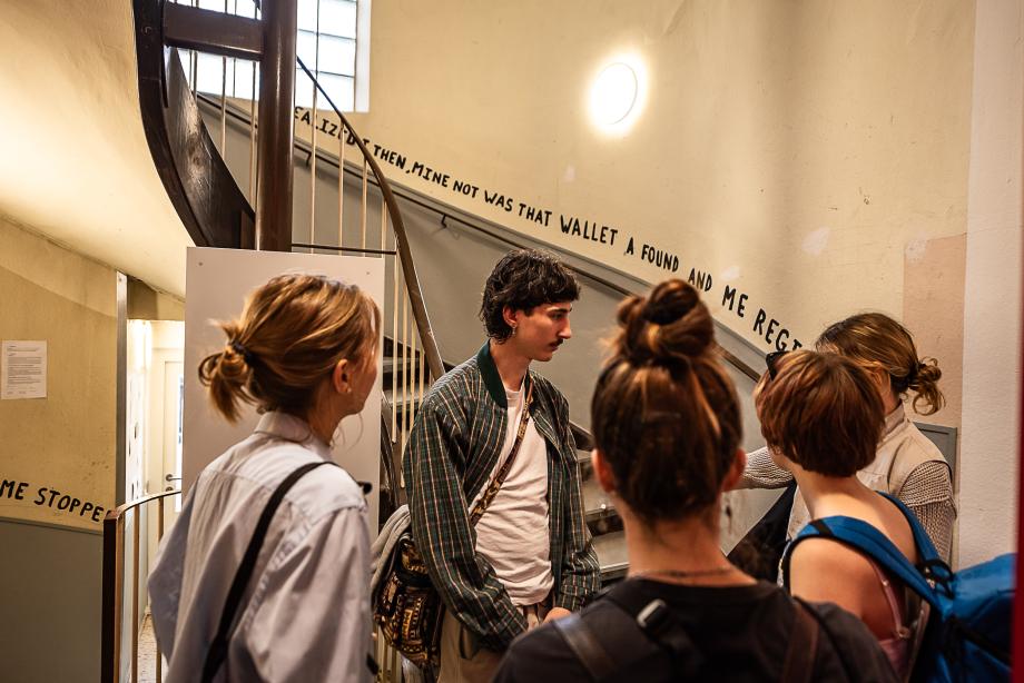 Menschen stehen an Treppenaufgang und reden miteinander.