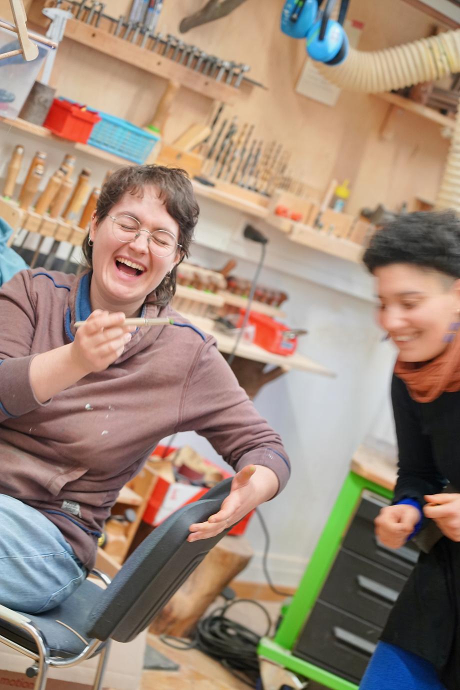 zwei Studentinnen lachen gemeinsam in der Figurentheaterwerkstatt.