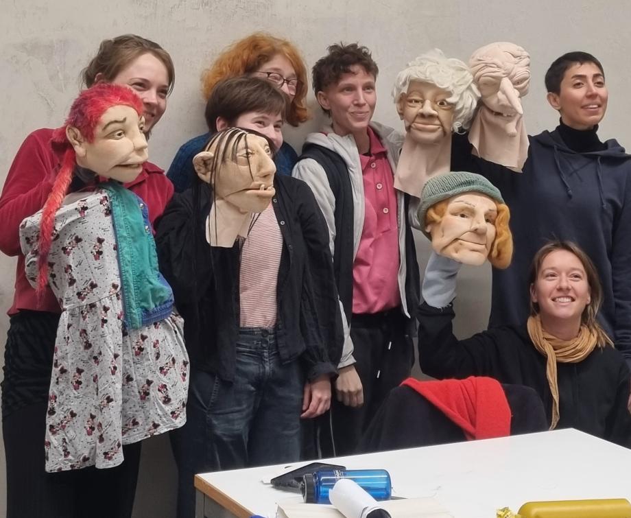 Studentinnen präsentieren ihre Figurenköpfe in ihren Händen.