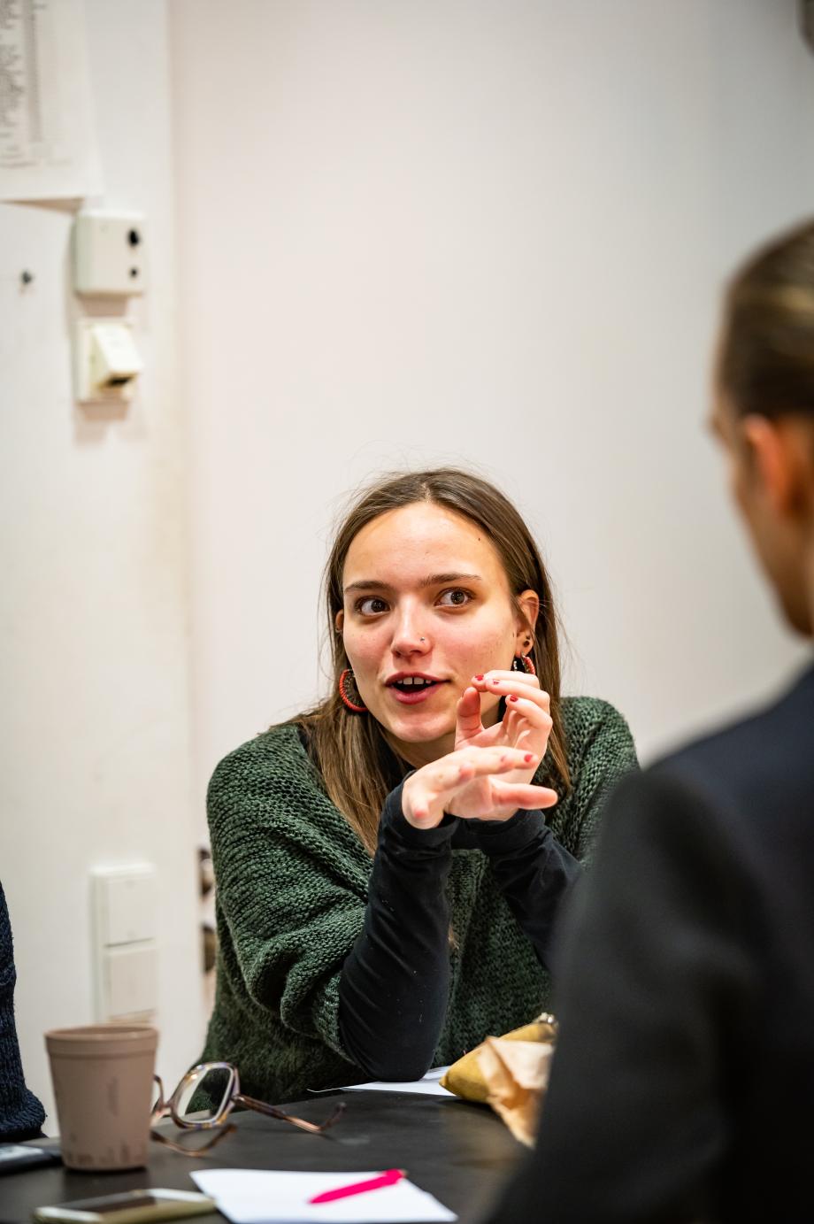 Frau spricht begeistert gegenübersitzende Person an.