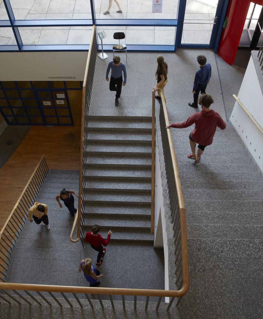 Studierende im Treppenhaus der Hochschule.