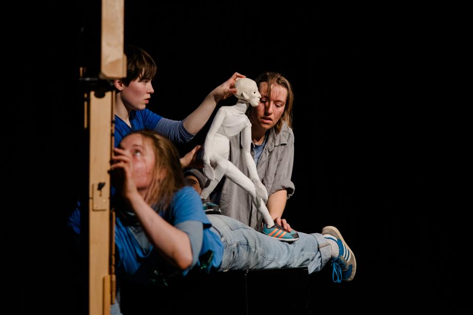 drei Frauen spielen mit einer Figur.