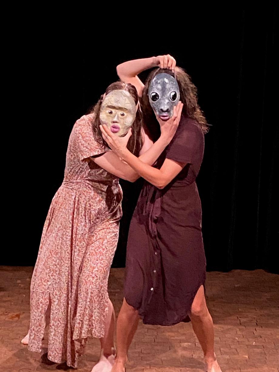 Zwei Frauen halten sich gegenseitig jeweils eine Maske vors Gesicht