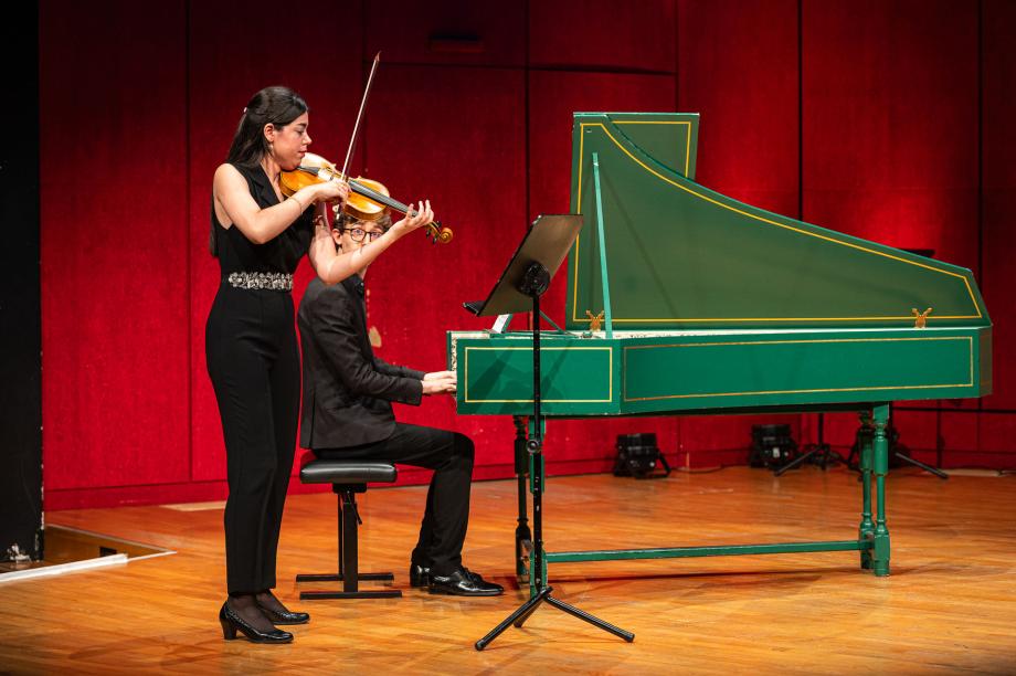 Geiegnstudentin mit Cembalostudent musizieren auf dem Konzertsaalpodium.