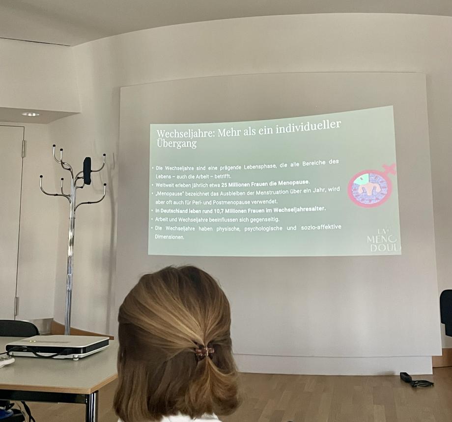 Es ist ein Teil der Präsentation zu sehen mit dem Titel "Wechseljahre: Mehr als ein individueller Übergang". 