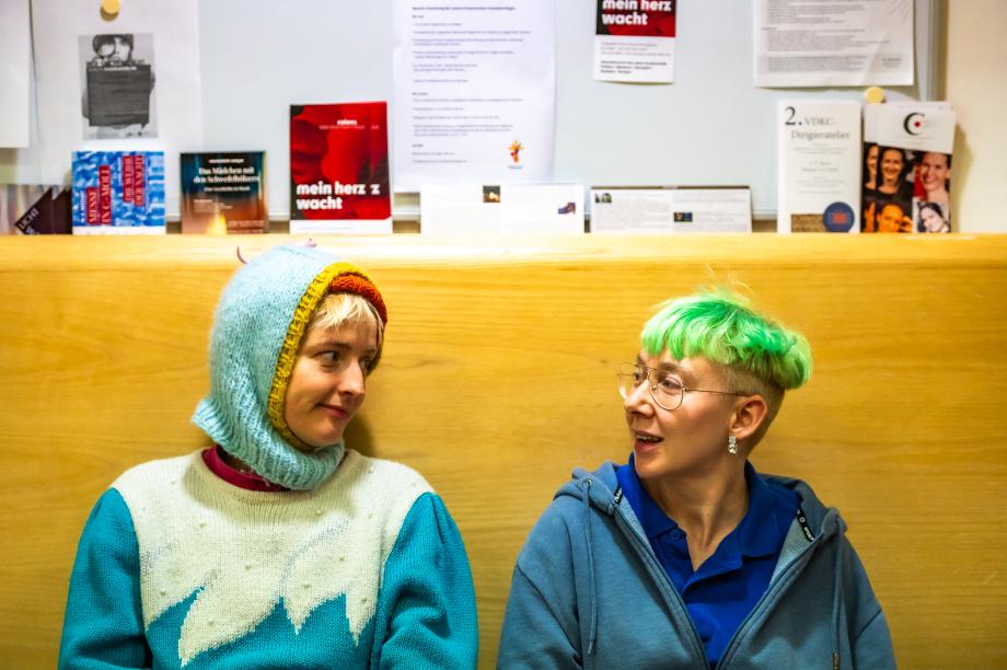 Zwei studierende unterhalten sich am Rande des Aktionstags auf der Bank in der Wandelhalle.