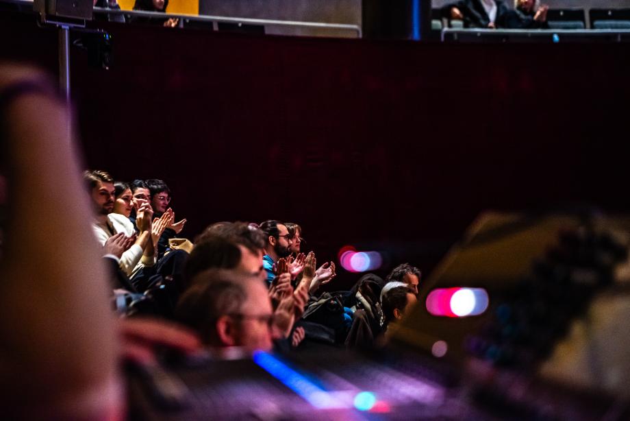 Blick von der Seite im dunklen Konzertsaal ins Publikum der Eröffnung und der Keynote.