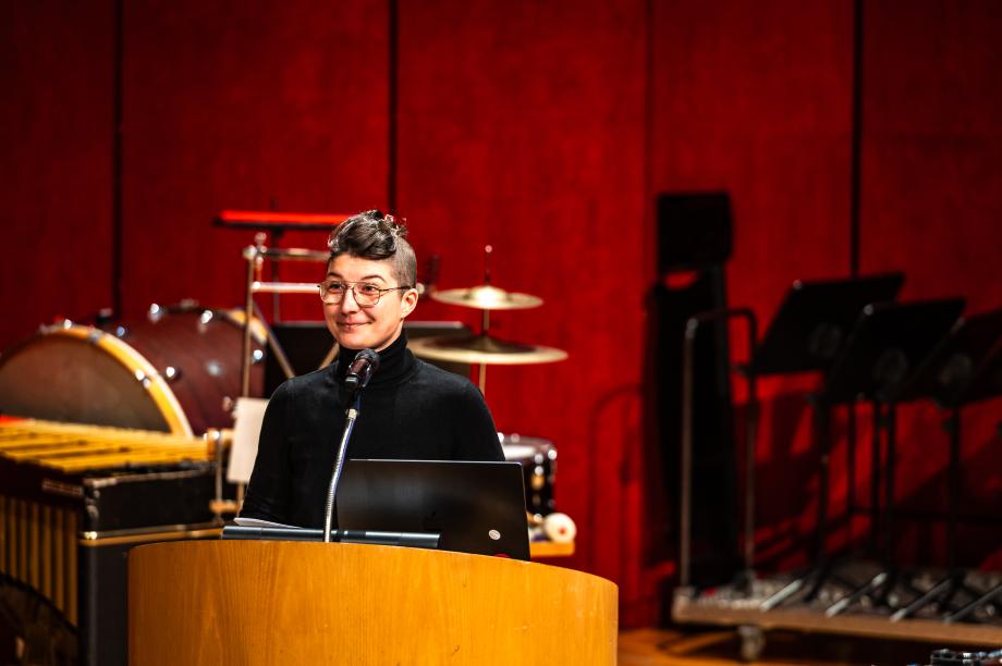 Keynotespeakerin Celin Klotz am Redner*innenpult des Konzertsaals.