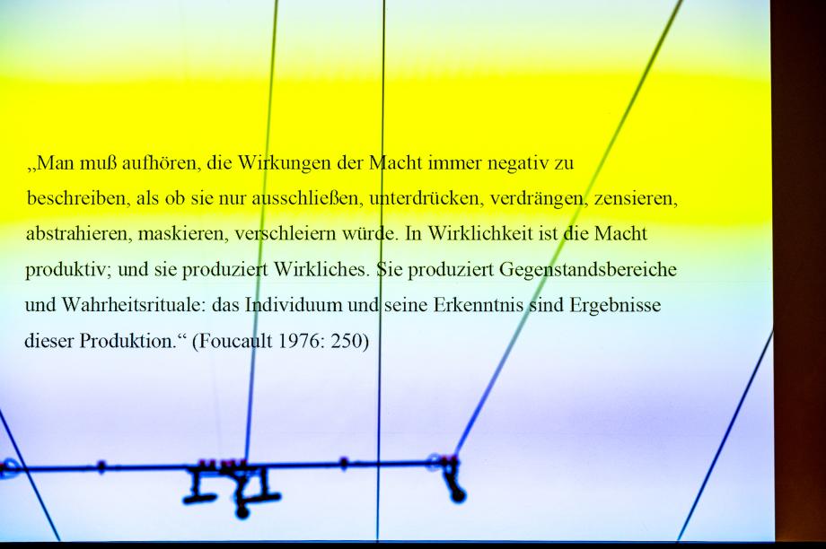 Blick auf die Leinwand des Konzertsaal mit dem Zitat von Foucault, auf das sich die Keynote bezieht.