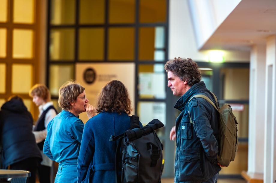 Teilnehmende in der Wandelhalle im Gespräch.