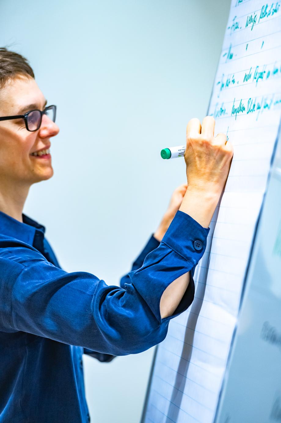 Britta Wirthmüller, Workshopleitende, schreibt Notizen auf ein Flipchart