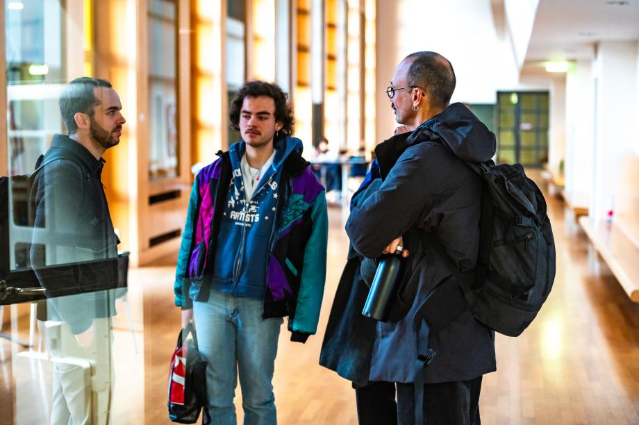 Studierende und Lehrende im Gespräch in der Wandelhalle