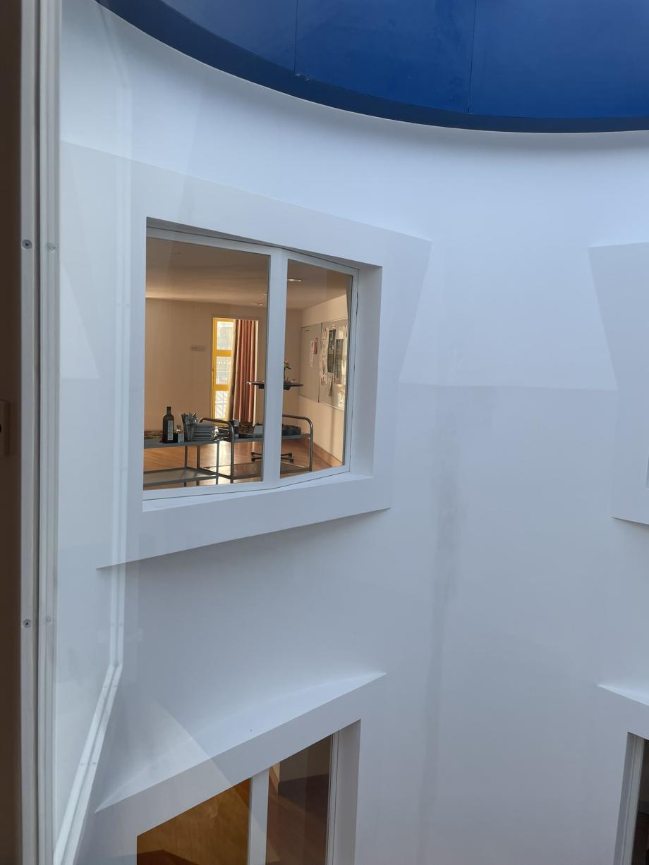 Blick auf ein Fenster an der Innenseite des Turms, ähnlich wie ein Schacht. Durch das Fenster sieht man einen beladenen Teewagen mit Essen und Getränken