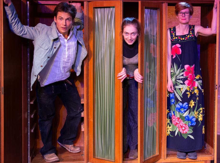 Zwei Schauspielerinnen und ein Schaspieler stehen in einem Schrank und gucken aus drei geöffneten Scvhranktüren heraus