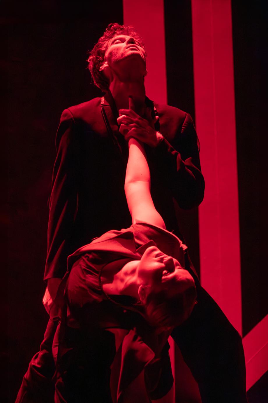 Ein Man und eine Frau tanzen, das Licht ist rot gefärbt