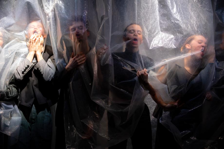 Vier Menschen mit schreienden Gesichtern hinter einer Folie