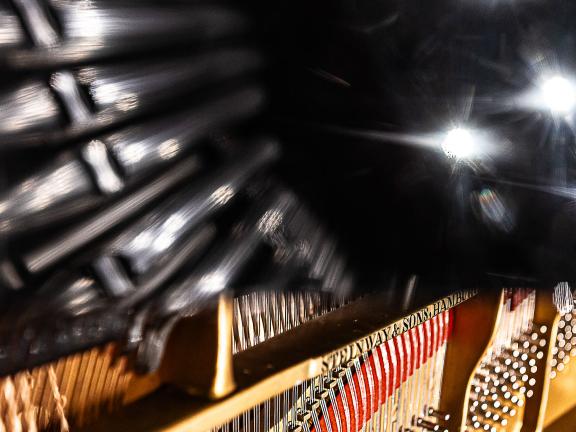 Detailaufnahme des Flügels, wo durch die Reflektion des Flügeldeckels die unterschiedlichen Beleuchtungskörper der Decke zu sehen sind.