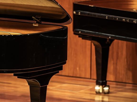 Ausschnitt zweier schwarzer Flügel auf einer Bühne.