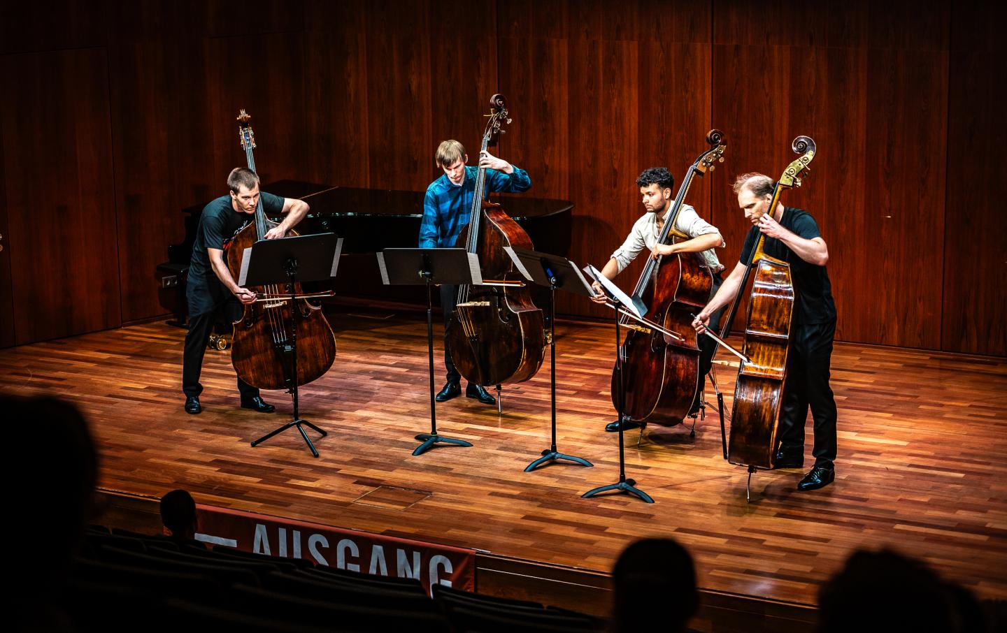 Vier Kontrabassisten stehen auf der Bühne im Kammermusiksaal